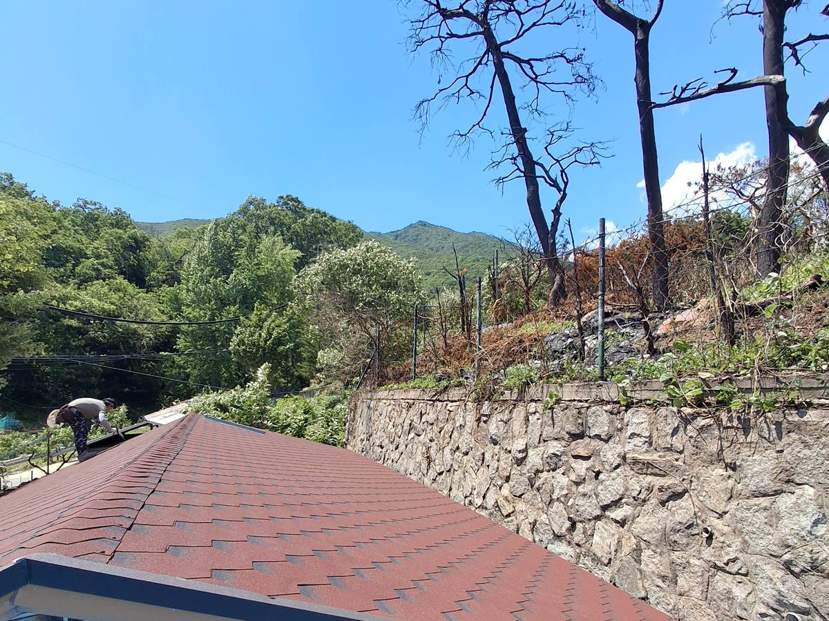 새 슁글과 용마루 캡 시공을 마친 지붕